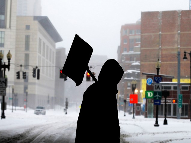 Homem carrega pá para retirar a neve do chão das ruas de Boston
