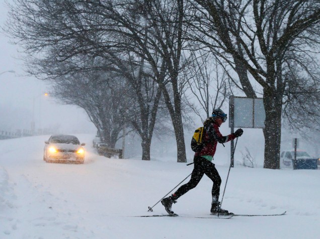 Mulher atravessa rua de Boston com equipamento de ski