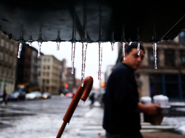 Homem passa por água congelada durante nevasca em Nova York