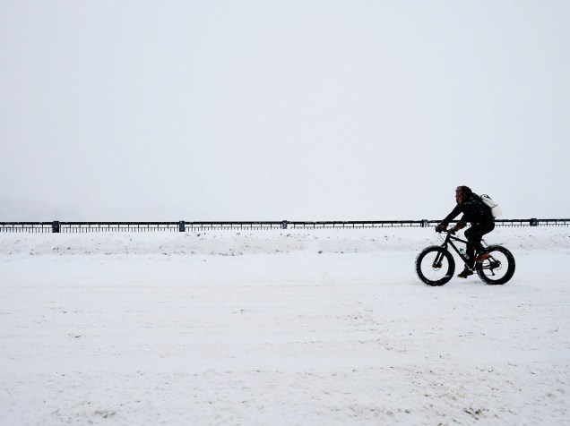 Ciclista passa pela ponte Mass Ave debaixo de nevasca em Boston, Massachusetts