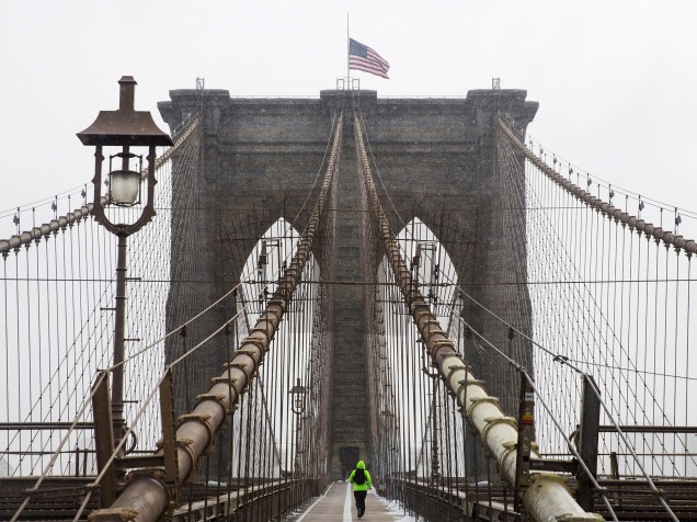 Homem corre enquanto nebrasca se aproxima da ponte do Brooklin, em Nova York