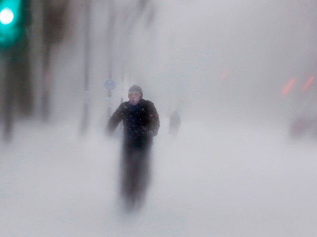 Homem anda de bicicleta durante nevasca na rua Beacon, em Boston, nos Estados Unidos