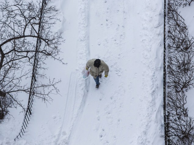 Homem caminha sobre a neve do leste de Nova York, após forte nevasca que atingiu parte dos Estados Unidos