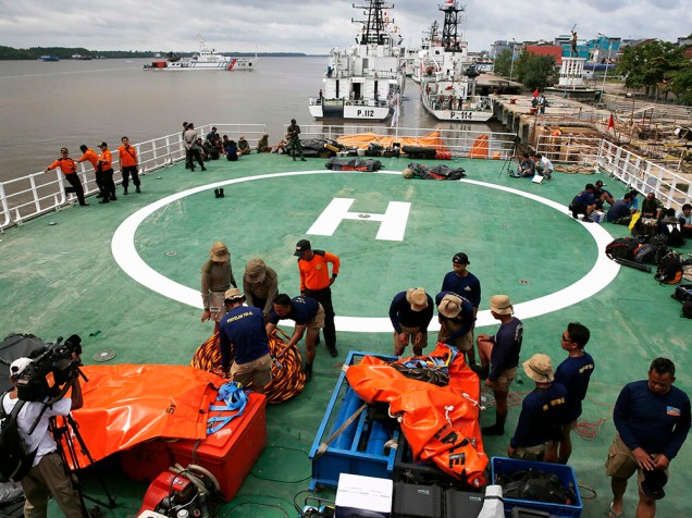 Mergulhadores da Marinha da Indonésia prepararam equipamentos na plataforma de um navio das forças nacionais antes da operação de busca aos passageiros do AirAsia QZ8501, no porto Kumai, no mar de Java