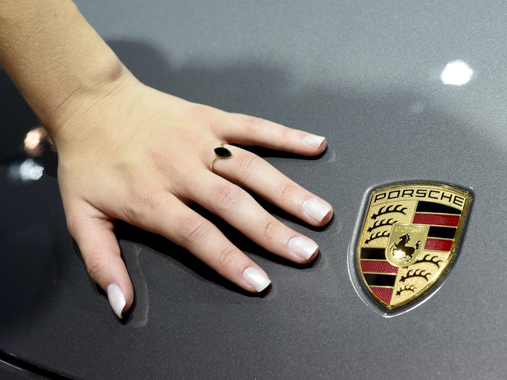 Modelo se apoia em um Porsche 911 Targa 4s no Salão do Automóvel 2014, em São Paulo