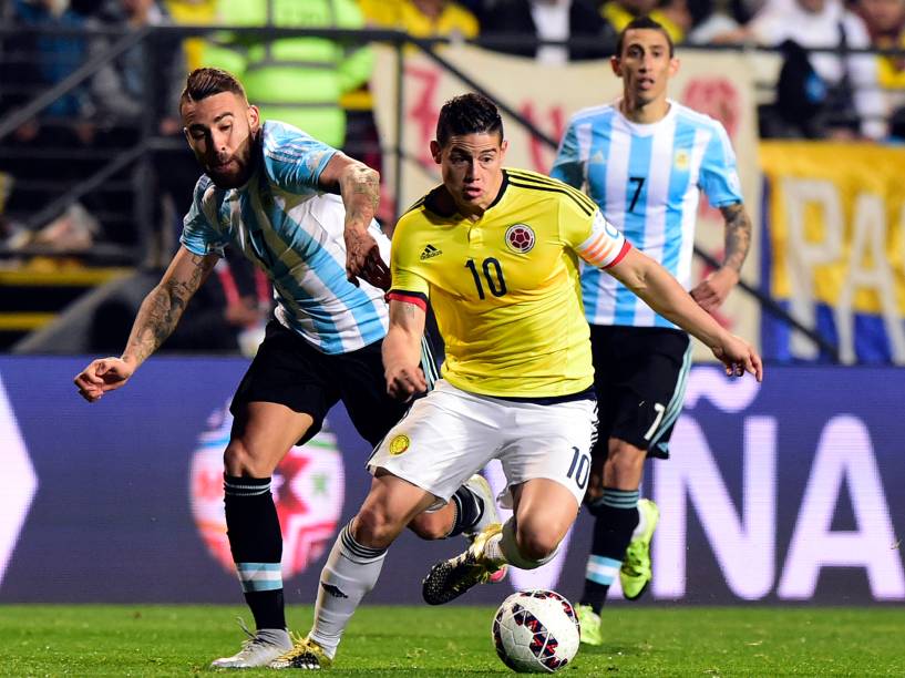 O meia colombiano James Rodríguez passa pela marcação do argentino Nicolás Otamendi