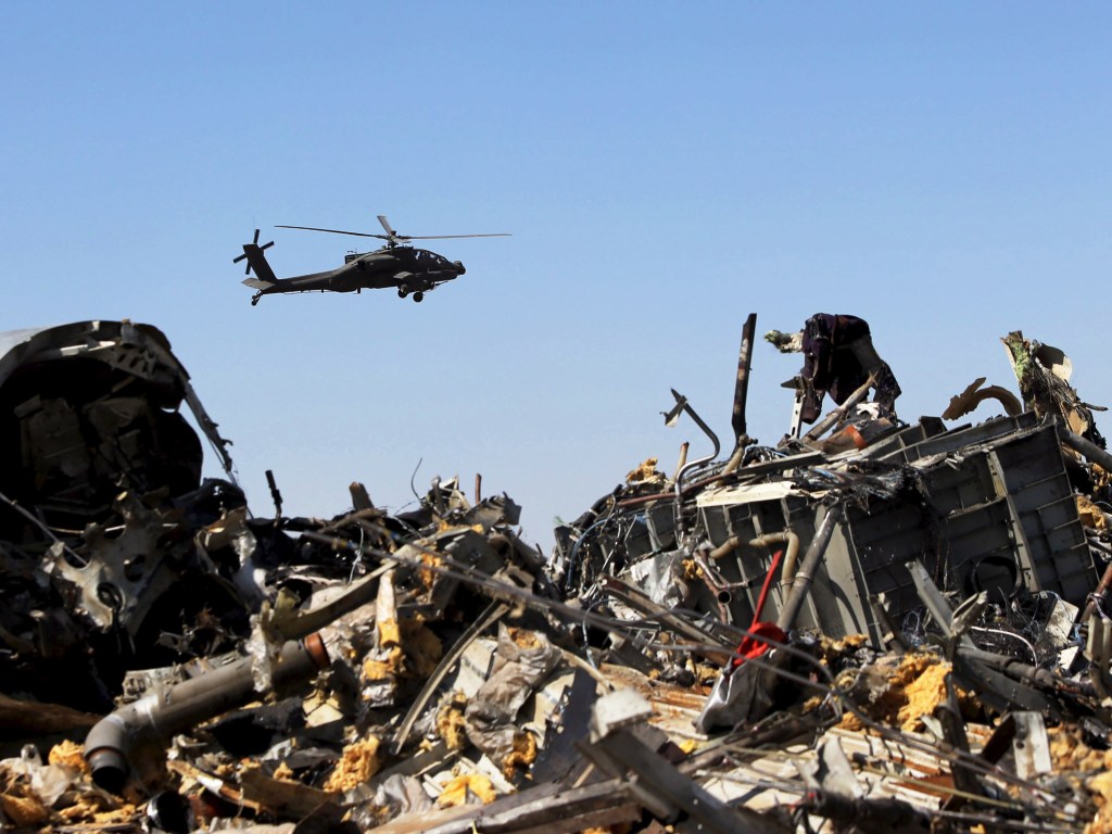 Um helicóptero militar egípcio sobrevoa os restos do avião russo que caiu na Península do Sinai, no Egito