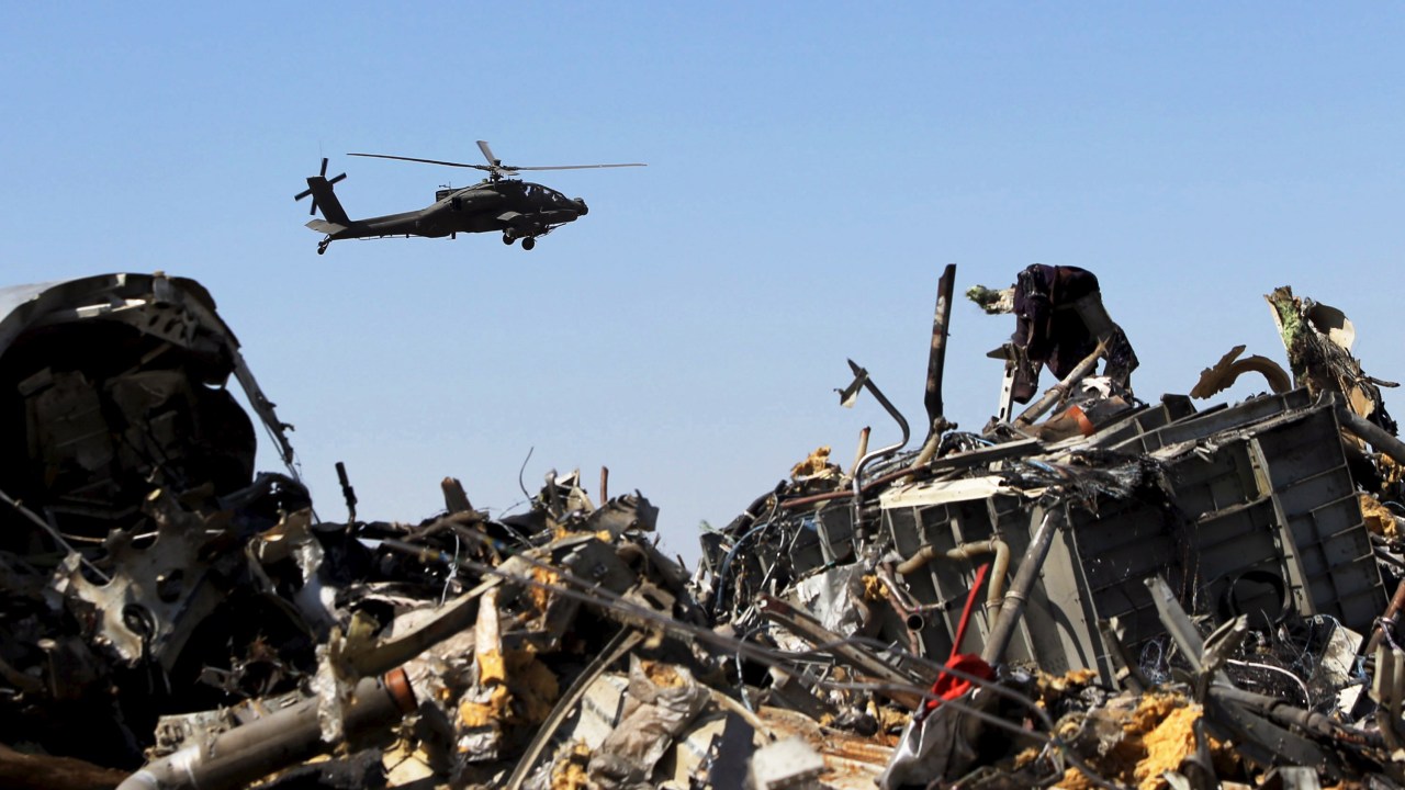 Um helicóptero militar egípcio sobrevoa os restos do avião russo que caiu na Península do Sinai, no Egito