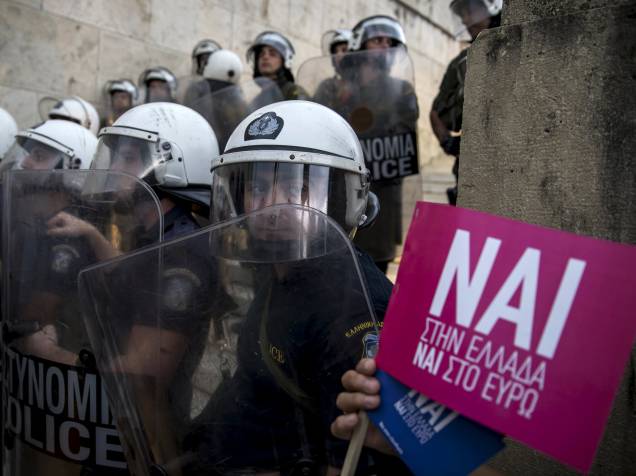 Tropas da polícia de choque se posicionam em frente ao parlamento grego, em Atenas, durante protesto a favor da permanência do país na zona do euro