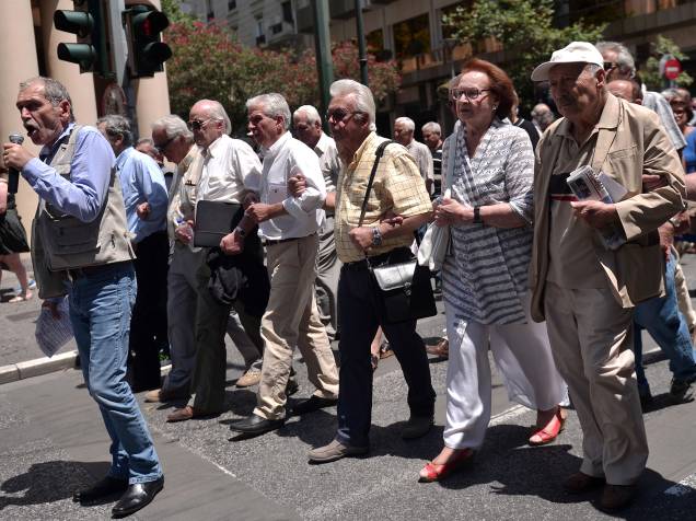 Aposentados andam pelas ruas de Atenas clamando por seus benefícios. O país limitou a retirada de 60 euros por dia nos caixas eletrônicos
