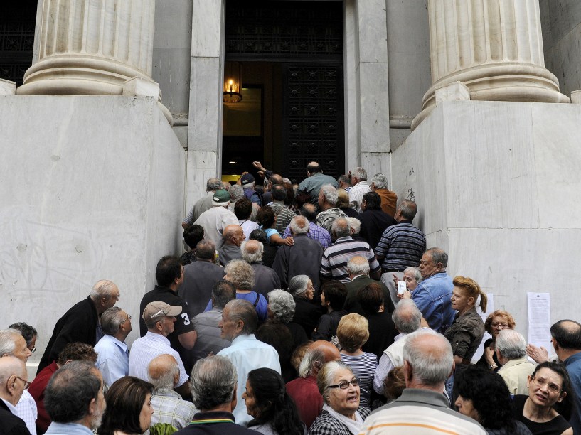 Aposentados aguardam em frente ao Banco Nacional para receber seus benefícios. Cerca de mil bancos pela Grécia abriraram nesta quarta-feira (01) para permitir que os pensionistas recebam uma pequena parcela de seus benefícios