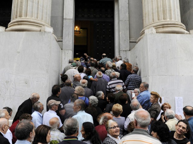 Aposentados aguardam em frente ao Banco Nacional para receber seus benefícios. Cerca de mil bancos pela Grécia abriraram nesta quarta-feira (01) para permitir que os pensionistas recebam uma pequena parcela de seus benefícios