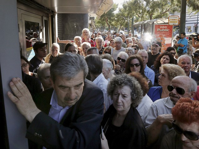 Aposentados gregos aguardam na fila em agência bancária em Atenas nesta quarta-feira (1º) após governo permitir que eles façam saques acima de limite imposto
