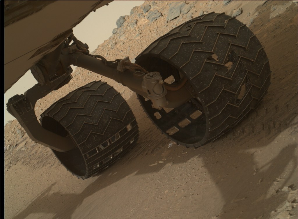 À direita, roda danificada, fotografada em 3 de agosto. As aberturas mais regulares, como as da toda à esquerda, são parte do projeto e não foram causadas pelo solo do planeta