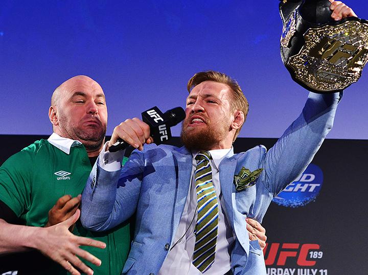 Dana White, com a camisa da Irlanda, segura McGregor depois de o irlandês "roubar" o cinturão do brasileiro José Aldo em evento em Dublin