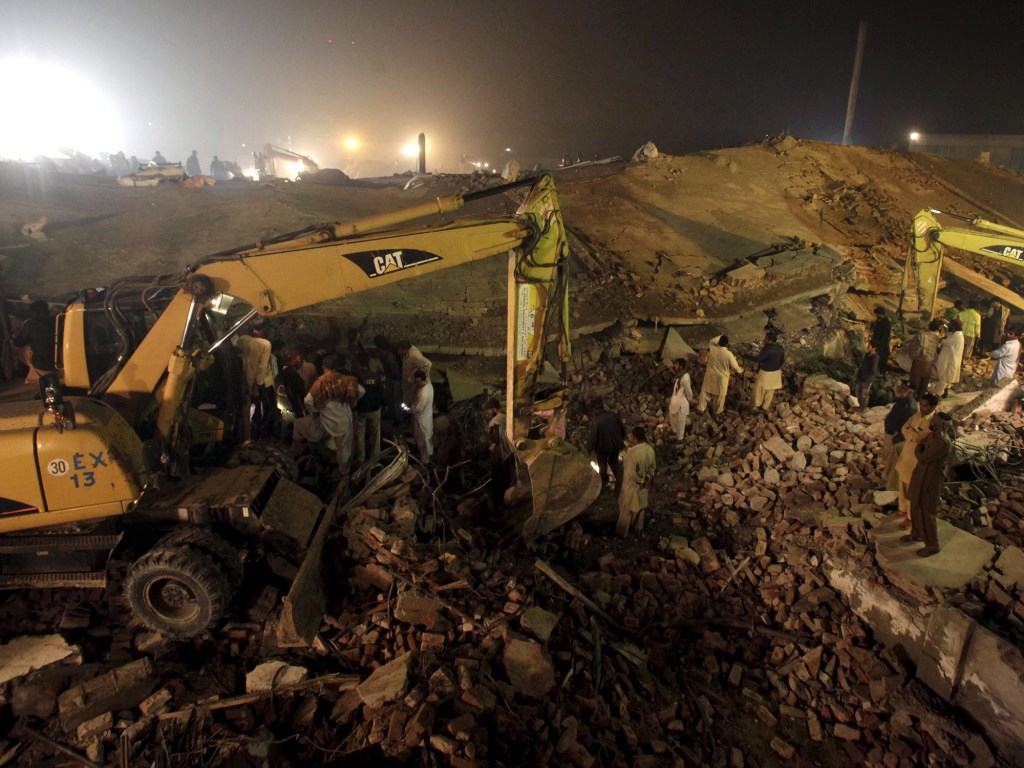 Trabalhadores procuram por sobreviventes após desmoronamento em uma fábrica no Paquistão