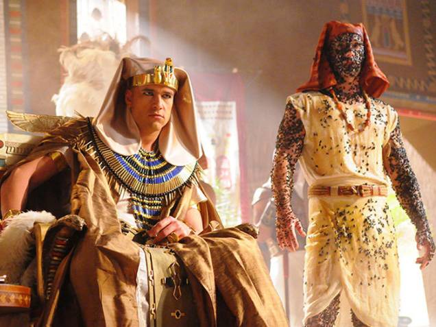 <p>Faraó Ramsés II (Sérgio Marone) besunta servo de doce para ficar livre das moscas, na quarta praga do Egito, em Os Dez Mandamentos</p>