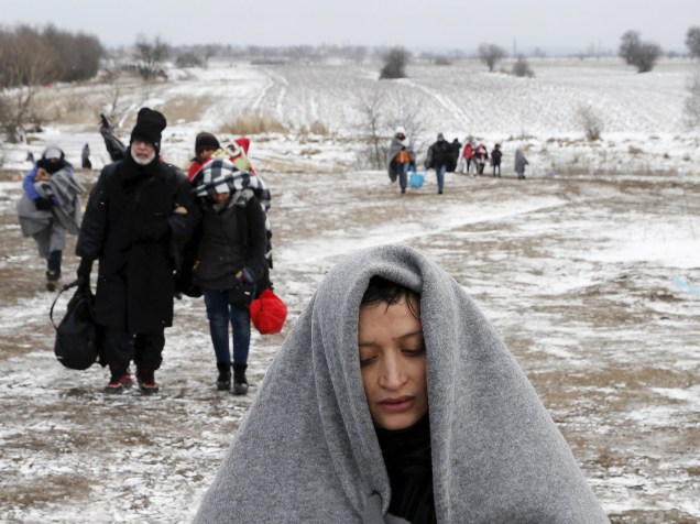 Uma refugiada caminha por um campo coberto de neve depois de cruzar a fronteira da Macedônia, em Miratovac, na Sérvia