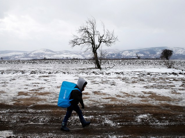 Uma criança refugiada caminha por um campo coberto de neve depois de cruzar a fronteira da Macedônia, em Miratovac, na Sérvia