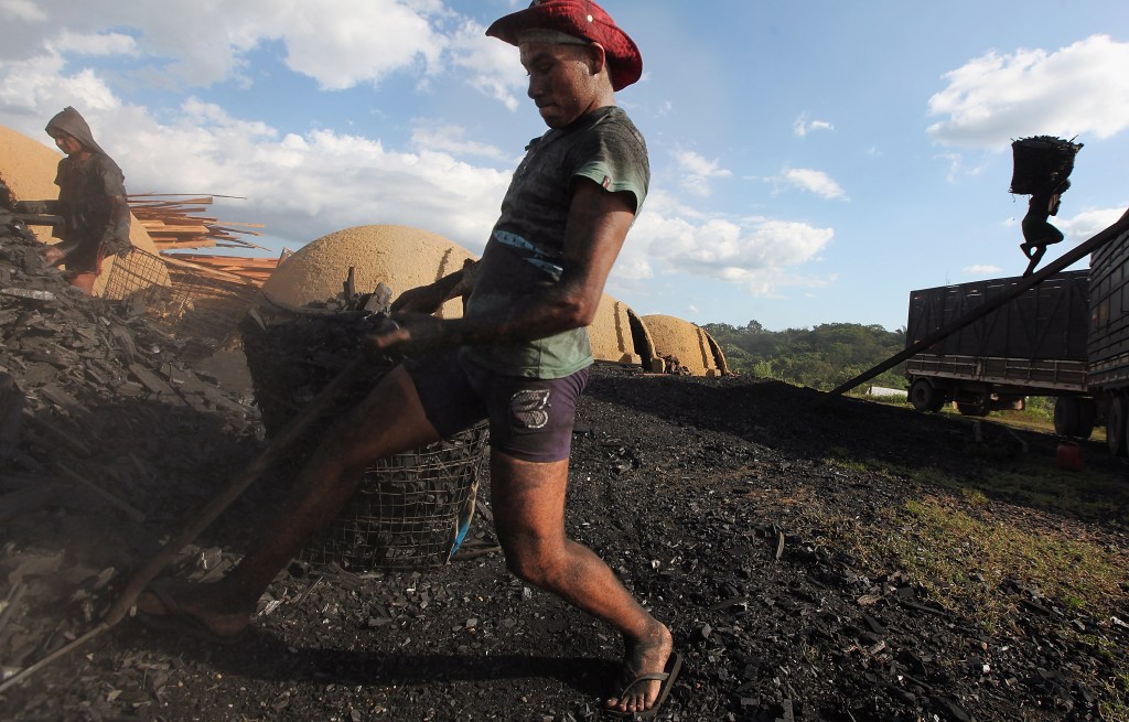 Trabalhadores carregam carvão produzido a partir de madeira extraída ilegalmente da floresta amazônica para um caminhão em Rondon do Pará - 08/06/2012