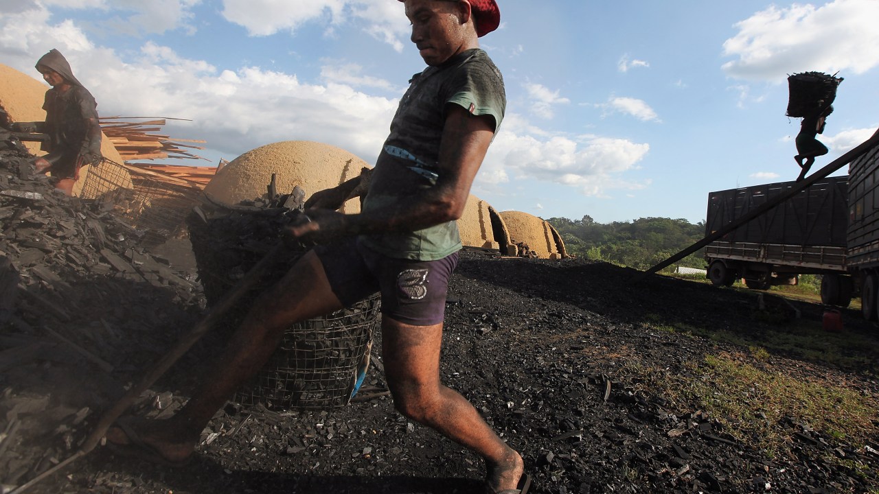 Trabalhadores carregam carvão produzido a partir de madeira extraída ilegalmente da floresta amazônica para um caminhão em Rondon do Pará - 08/06/2012