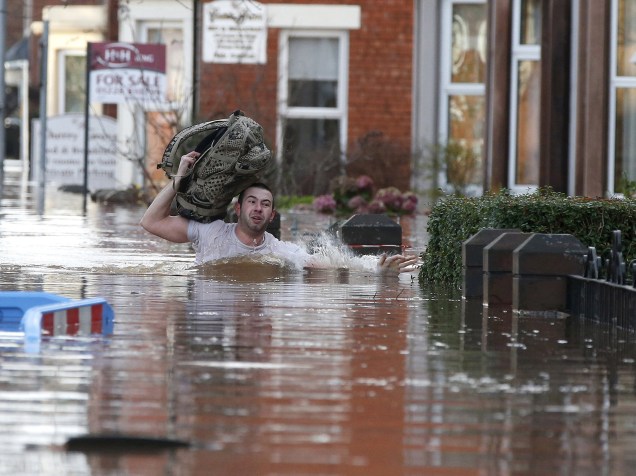 Morador de Carlisle, na Grã-Bretanha, tenta se proteger de tempestade após fortes chuvas na região