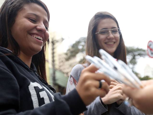Estudantes recebem canetar para realizar a prova enquanto aguardam o início do Enem 2015
