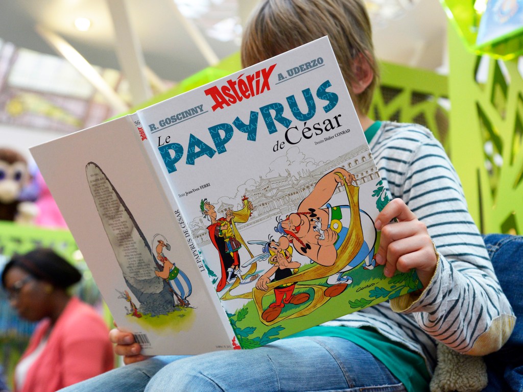 Em Paris, criança lê 'O Papiro de Cesar', 36º álbum do rebelde gaulês Asterix lançado mundialmente