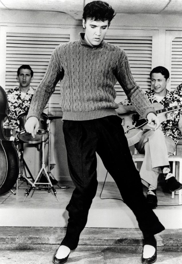 Elvis Presley canta e dança com sua banda em um filme no ano de 1956