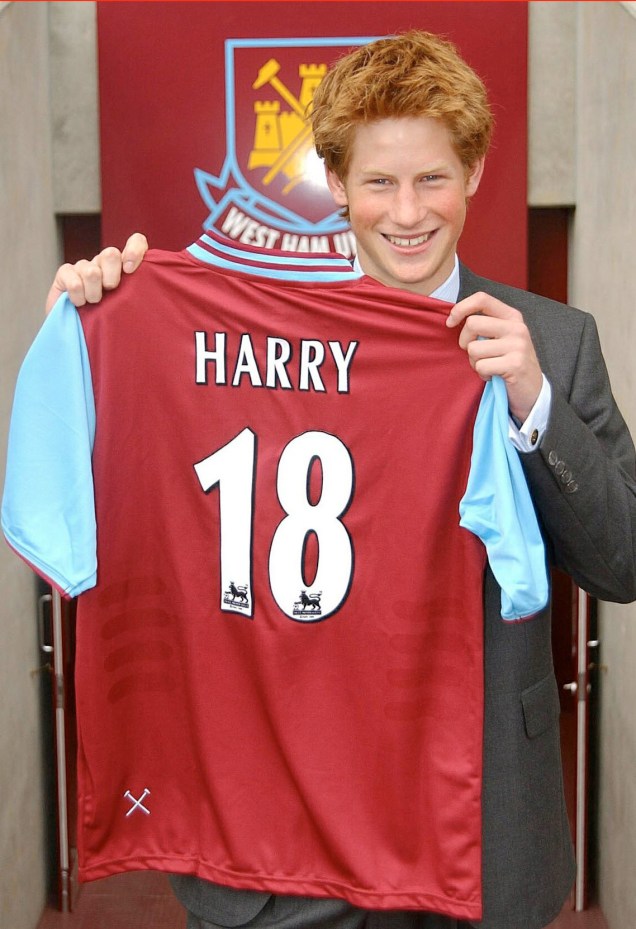 Príncipe Harry segura camisa em homenagem ao seu aniversário, durante uma visita ao Upton Park, em Londres, Inglaterra, em 2002