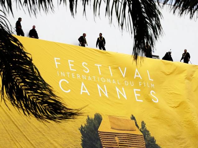 Trabalhadores estendem banner do Festival Internacional de Cannes, no Palais des Festivals, no Sul da França - 10/05/2016