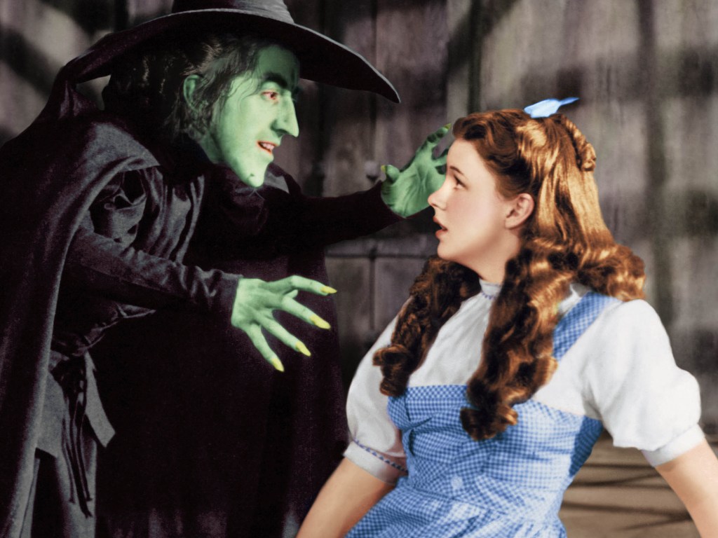Margaret Hamilton (1902 - 1985) como a Bruxa Má e Judy Garland (1922 - 1969) como Dorothy Gale em O Mágico de Oz, de 1939