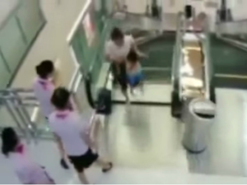 Mulher e seu filho momentos antes do chão ceder, em um shopping na China