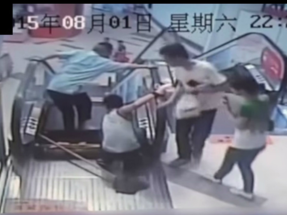 Funcionário de limpeza fica preso em escada rolante em um shopping na China
