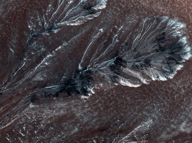 <p>Esta imagem, capturada em 30 de julho de 2015 pela Missão Mars Reconnaissance Orbiter (MRO), retrata uma geada sazonal que se forma em médias e altas latitudes de Marte. Segundo cientistas, esse fenômeno é bem parecido com a neve na Terra e pode causar as voçorocas na superfície marciana.</p>