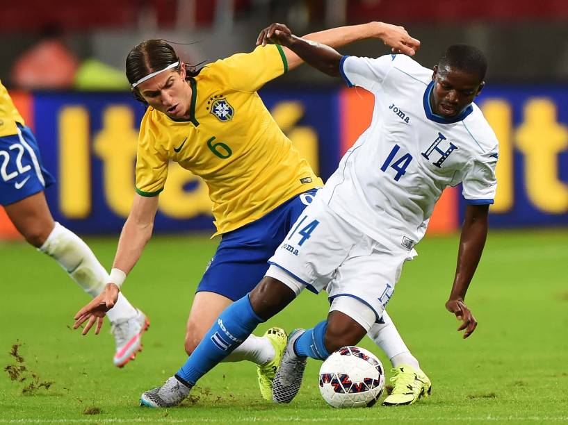 O lateral da seleção brasileira Filipe Luís divide jogada com o zagueiro Óscar García de Honduras