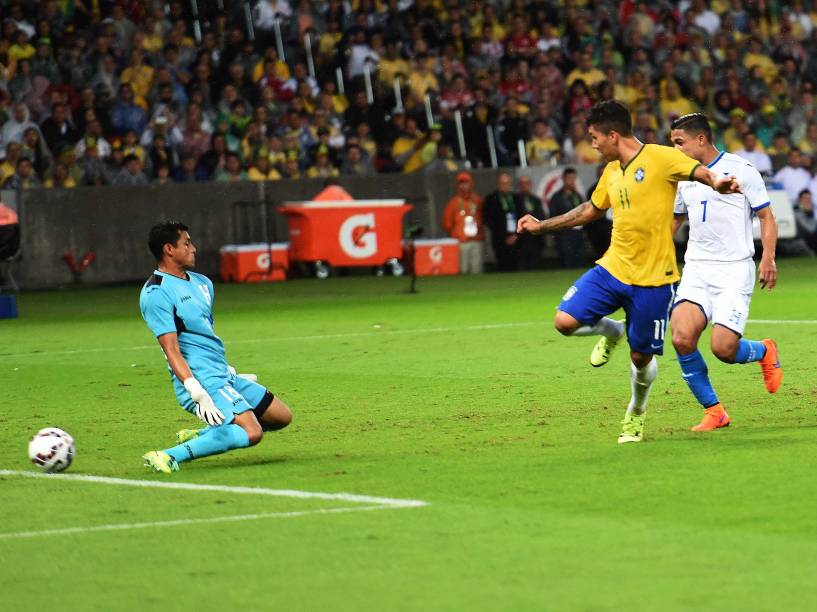 O atacante Roberto Firmino do Brasil toca na saída do goleiro para o abrir o placar na partida contra Honduras