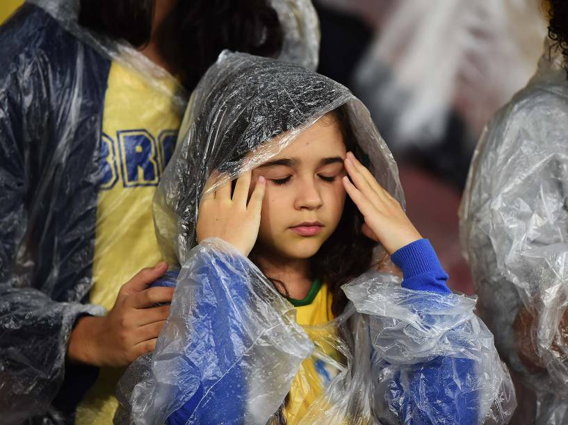 Torcedora se protege da chuva durante amistoso entre Brasil e Honduras
