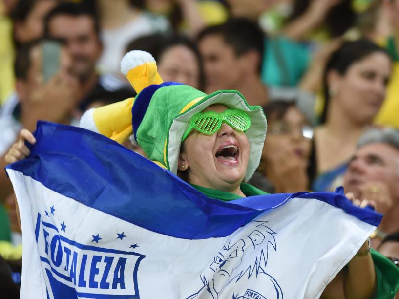Torcedora segura a bandeira do Fortaleza na partida entre Brasil e Venezuela no Castelão