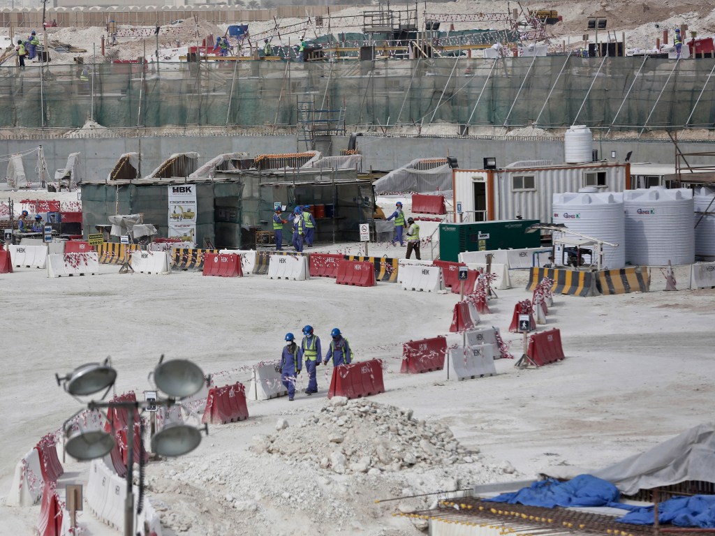 Foto de maio de 2015 mostra trabalhadores estrangeiros entre barreiras de segurança no local do gramado do Estádio Al-Wakra em construção para a Copa do Mundo de 2022 em Doha, no Catar