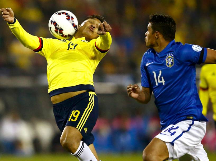 O atacante colombiano Teófilo Gutiérrez domina a bola enquanto é marcado pelo zagueiro Thiago Silva do Brasil
