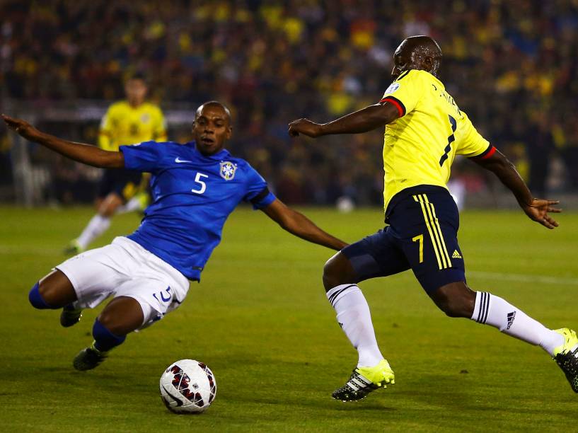 O lateral colombiano Pablo Armero é marcado pelo volanta brasileiro Fernandinho