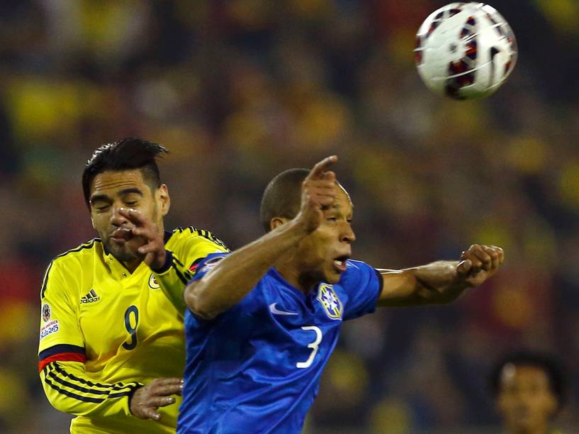 O zagueiro Miranda da seleção brasileira disputa pelo alto com o atacante colombiano Falcão García