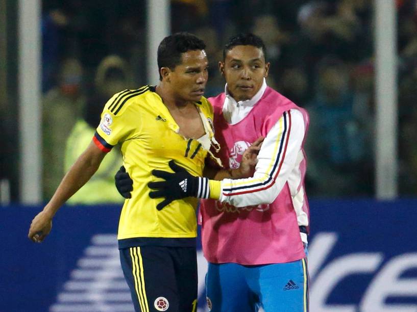O jogador colombiano Carlos Bacca sai com a camisa rasgada após confusão no final da partida contra o Brasil