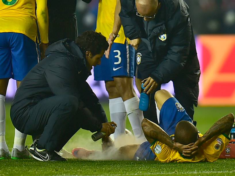 O lateral direito da seleção brasileira Daniel Alves recebe atendimento médico em campo após sofrer pancada