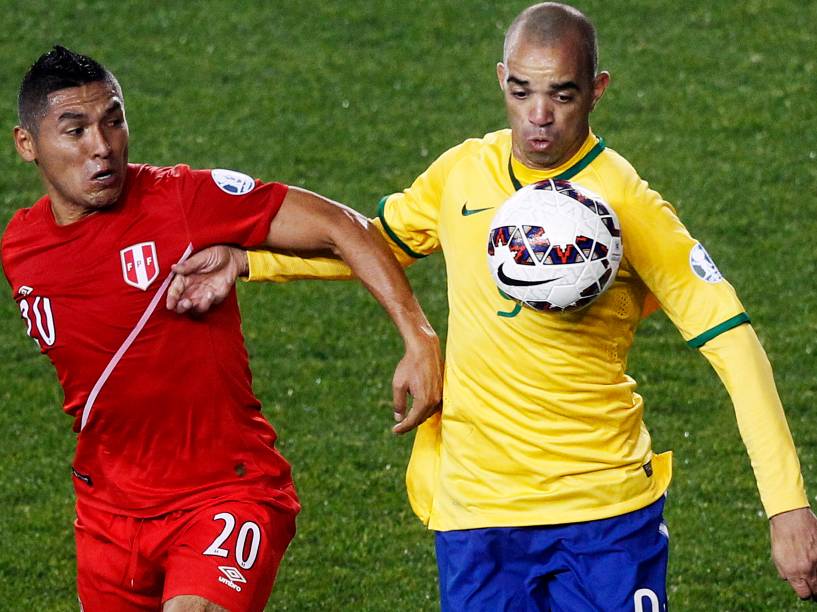 O peruano Joel Sánchez divide jogada com o brasileiro Diego Tardelli