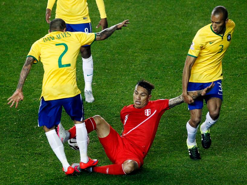 O atacante peruano Paolo Guerrero comete entrada violenta no lateral direito Daniel Alves do Brasil