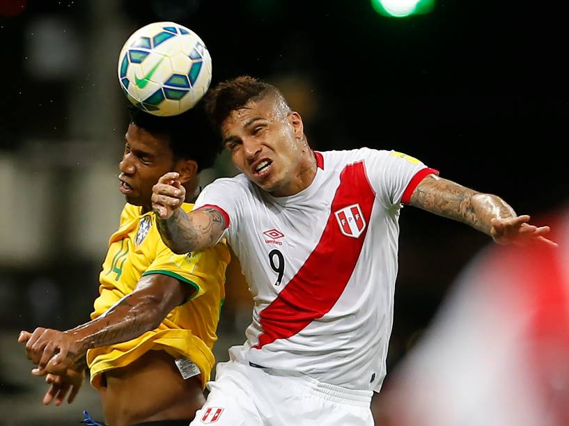 O zagueiro Gil da seleção brasileira disputa a bola com o atacante peruano Paolo Guerrero