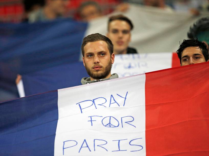 Torcedor segura uma bandeira francesa com a inscrição "Reze por Paris" antes do amistoso entre Inglaterra e França no Estádio de Wembley - 17/11/2015