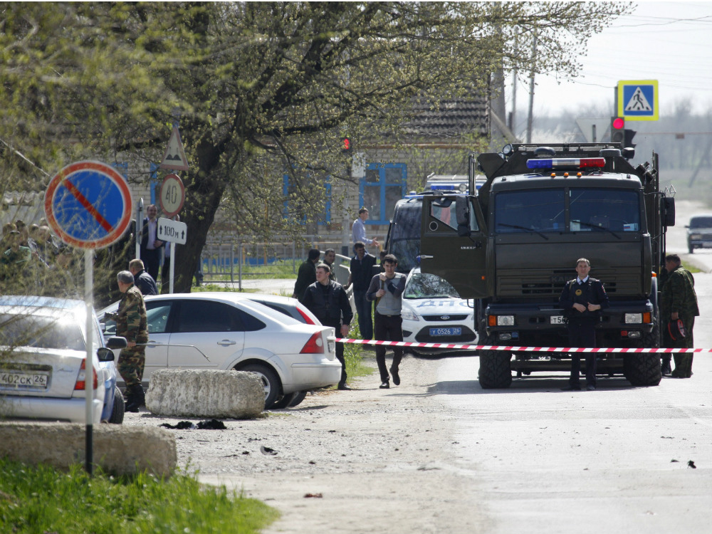 Policiais no local onde três terroristas se explodiram, em Novoselskoye, na Rússia
